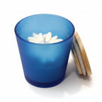 Blue candle holder with a white floral design on a dark surface