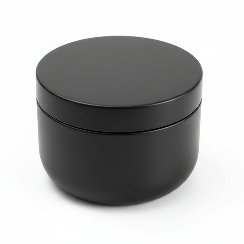 Matte black round candle container with lid on a white background, minimalist design