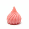 Pink sculptural swirl candle with geometric design on white background
