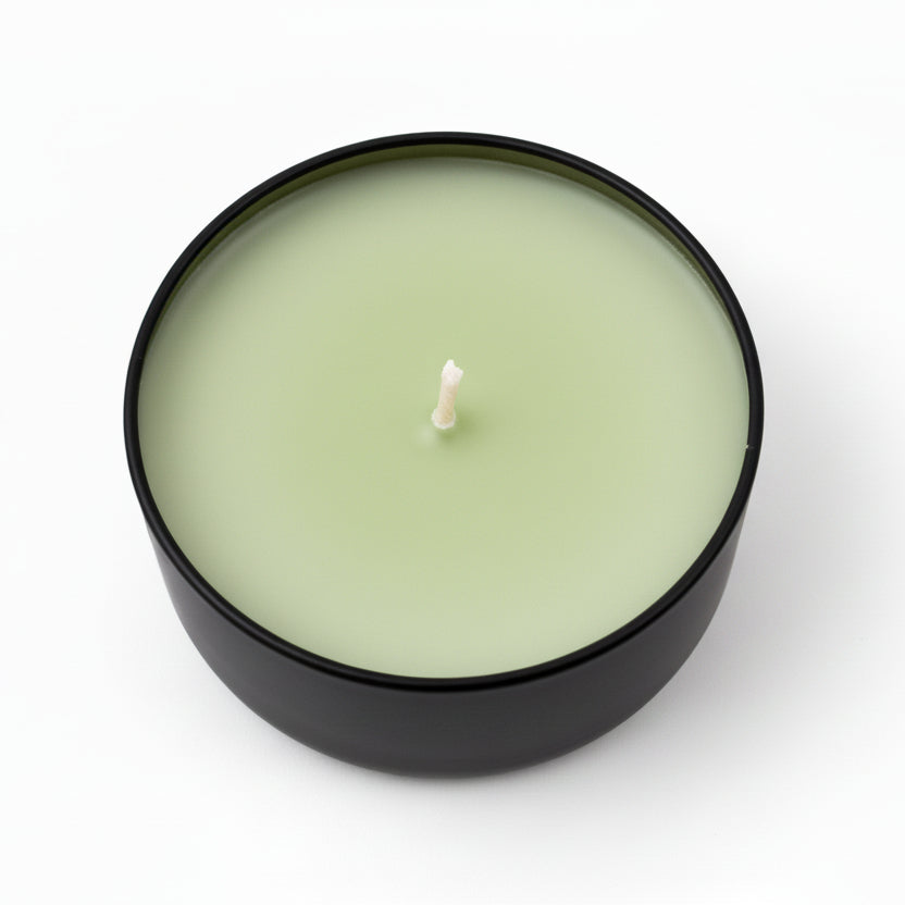 Lemongrass coconut scented candle in a black round container on white background