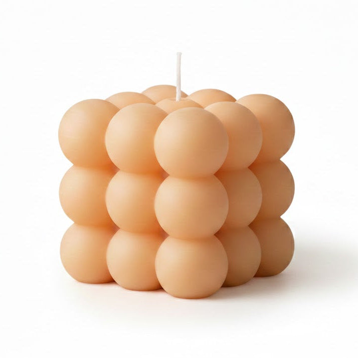 Beige geometric bubble cube candle made from natural wax on a white background